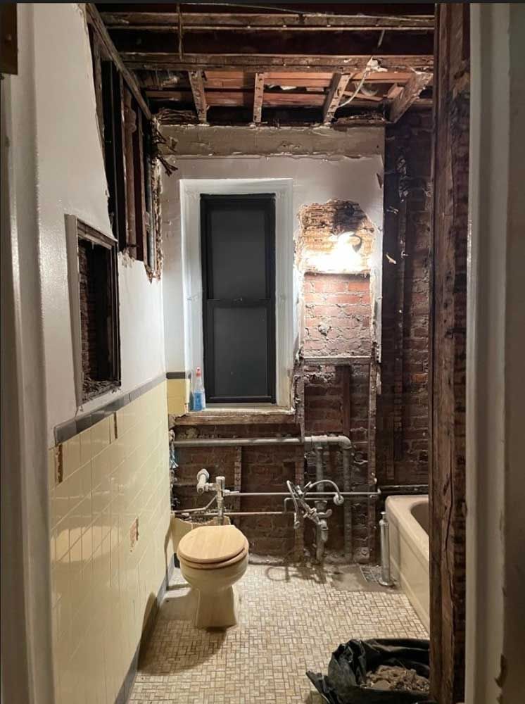 A bathroom with a toilet, bathtub and window