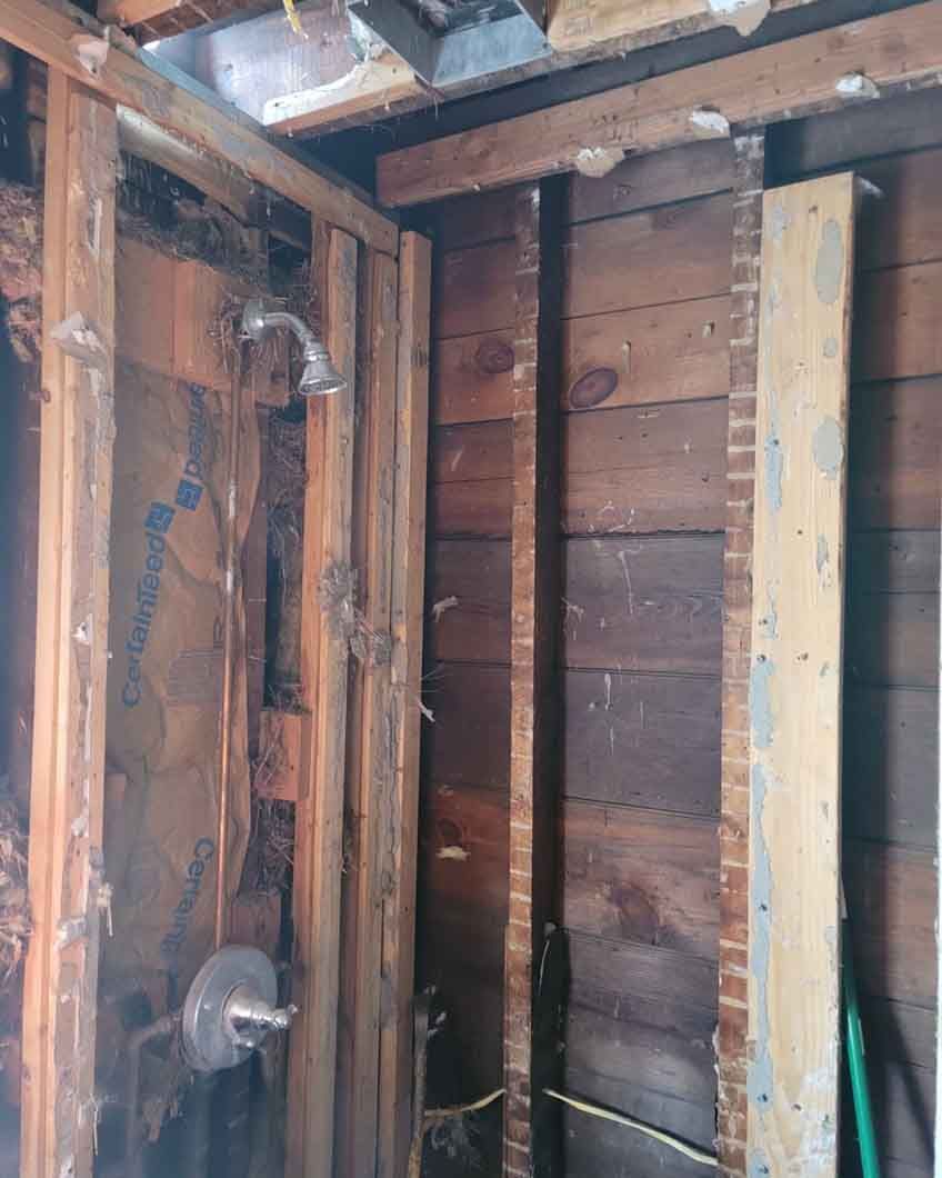 A wooden wall with a shower head in it