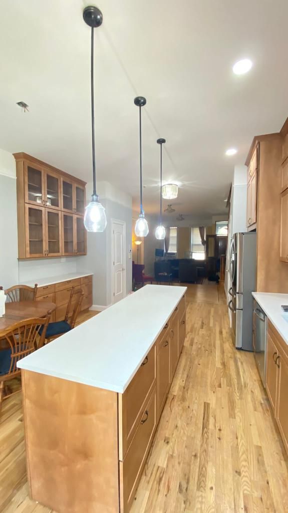 A kitchen with wooden cabinets and a large island in the middle
