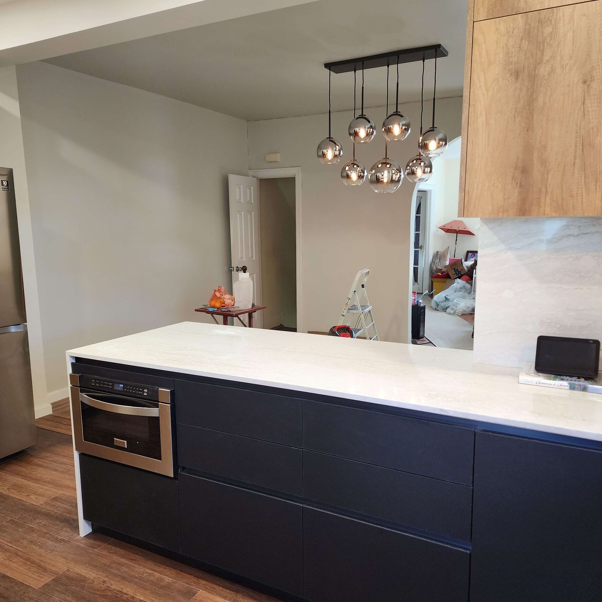 A kitchen with black cabinets and a white counter top