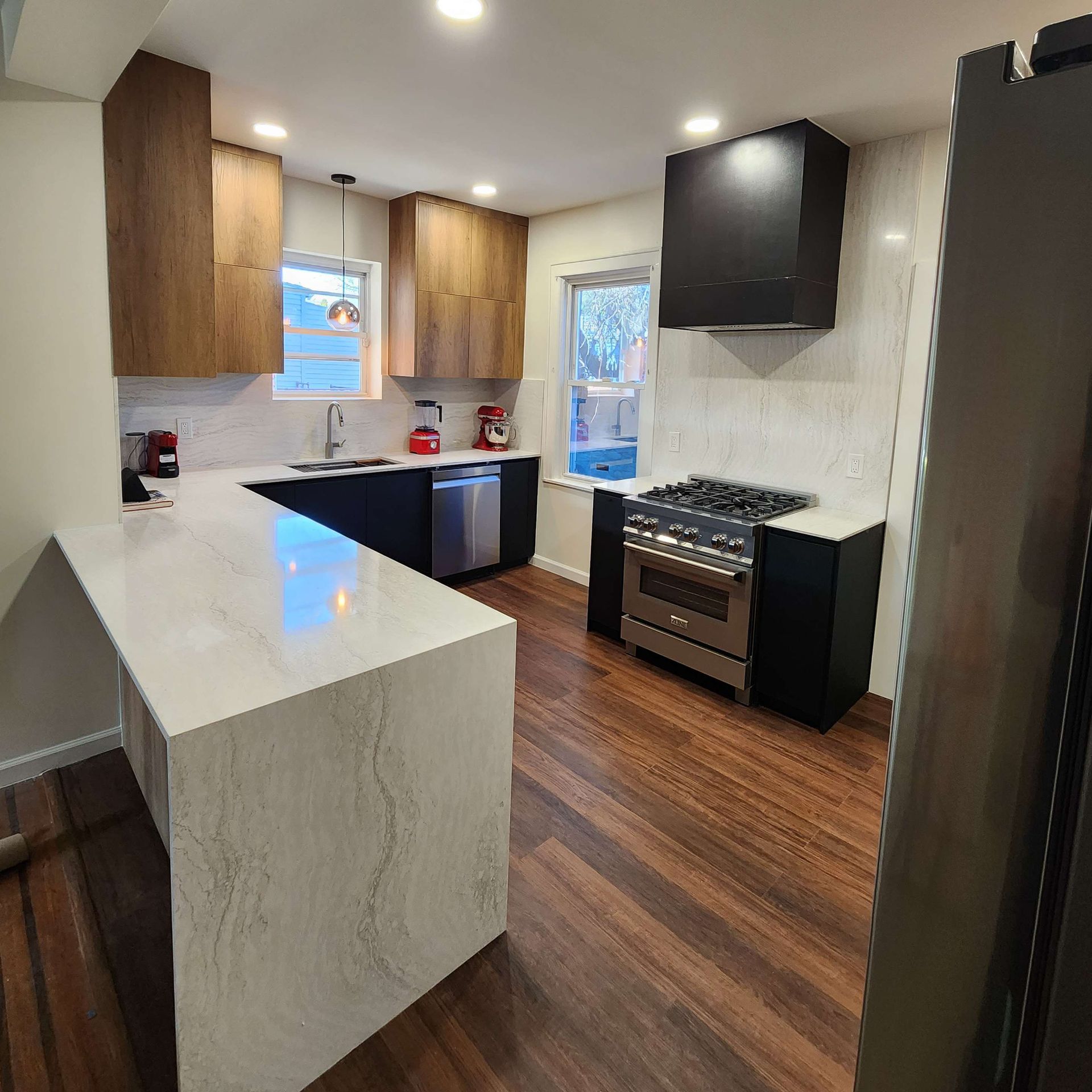 A kitchen with stainless steel appliances and wooden floors