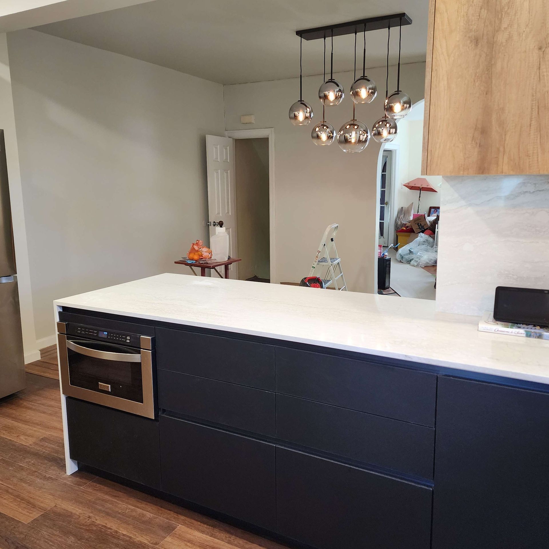 A kitchen with black cabinets and white counter tops