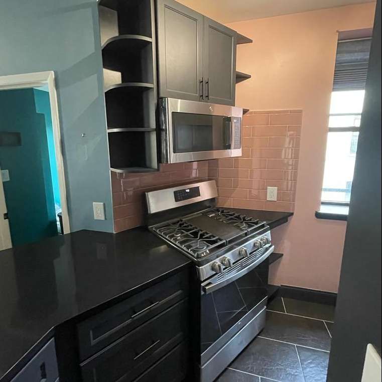 A kitchen with a stove top oven and a microwave