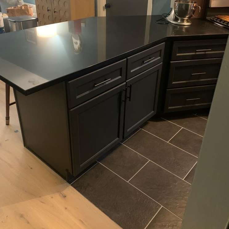 A kitchen with black cabinets and a black counter top