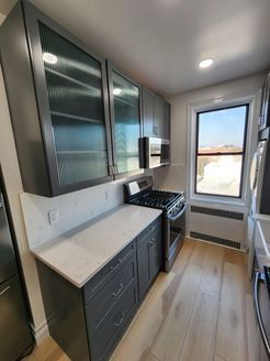 A kitchen with a stove, microwave, refrigerator and cabinets