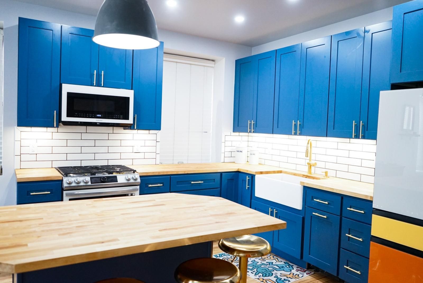 A kitchen with blue cabinets and a wooden counter top