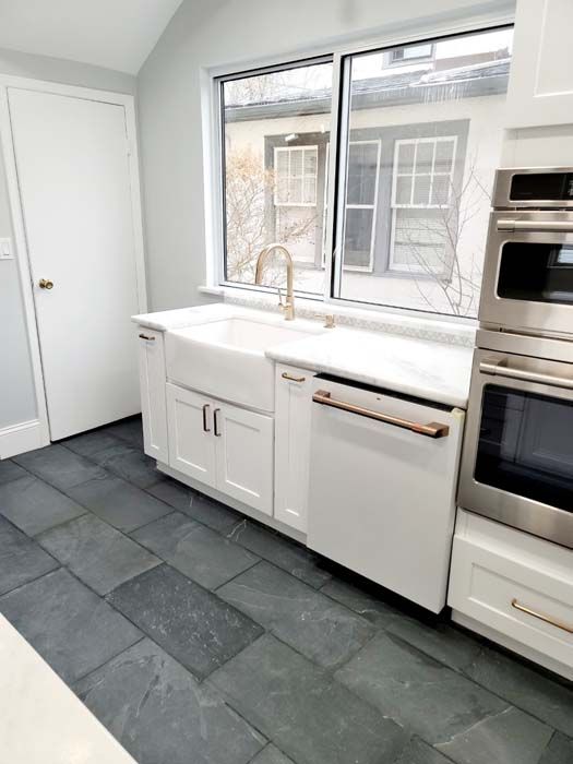A kitchen with stainless steel appliances, a sink, and a window
