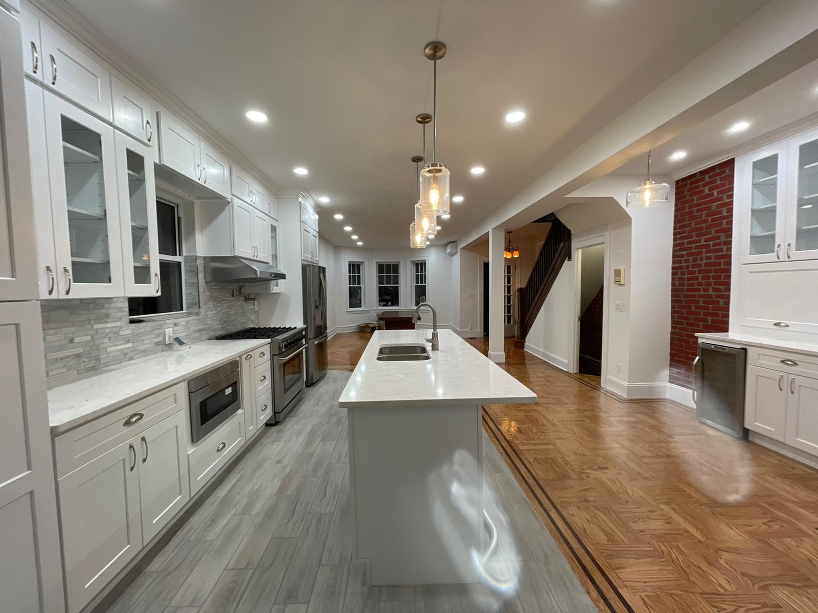 A kitchen with white cabinets and a large island in the middle
