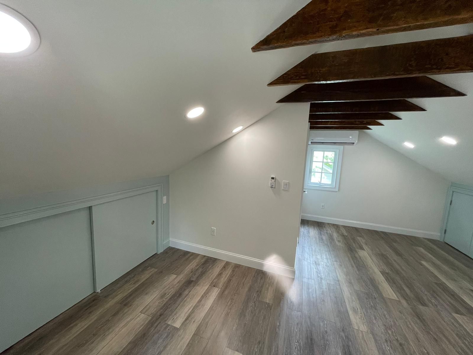An empty attic with wooden floors and a window