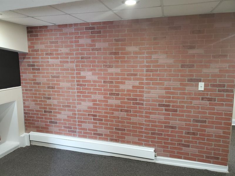 A room with a red brick wall and a white radiator