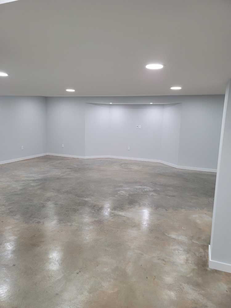 An empty basement with a concrete floor and white walls