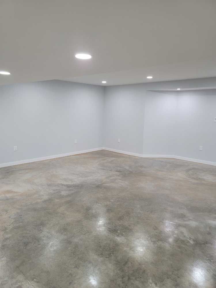 An empty basement with a concrete floor and white walls