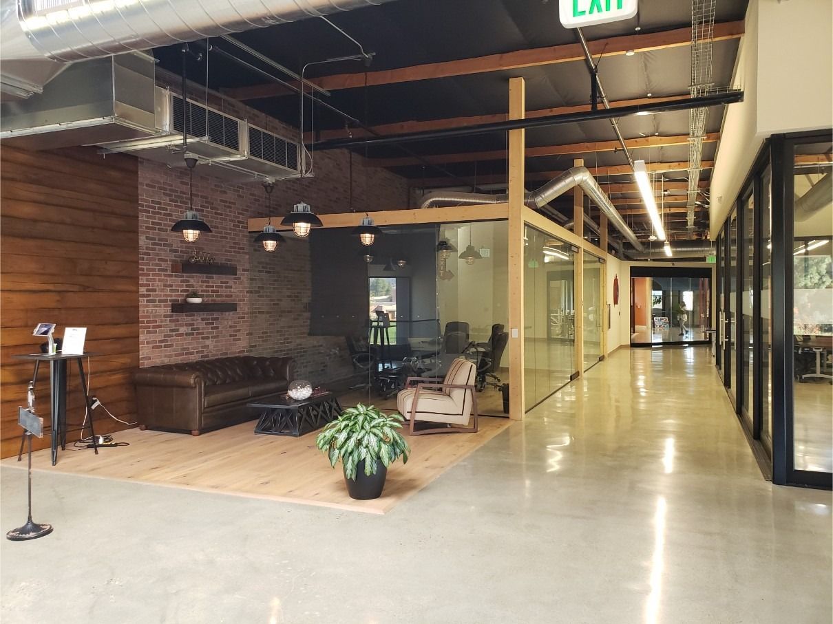 A long hallway in an office building with a green exit sign.