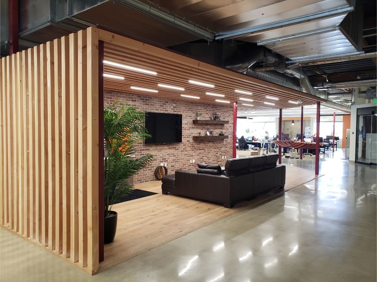 A living room with a couch and a television in a large room.