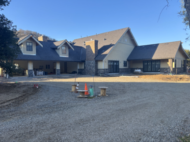 A large house with a gravel driveway in front of it