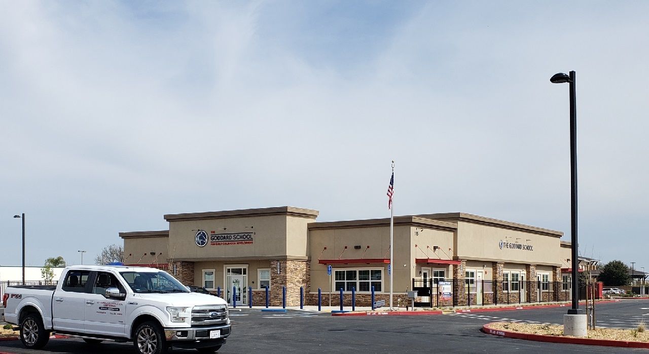 A white truck is parked in front of a building.