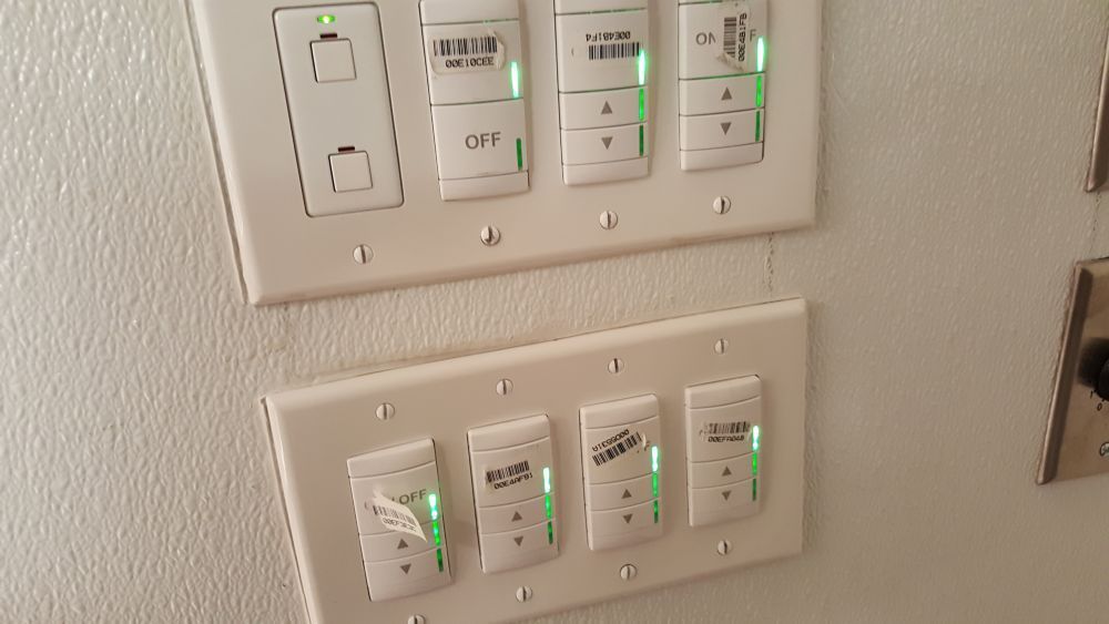 A wall with a bunch of light switches on it.