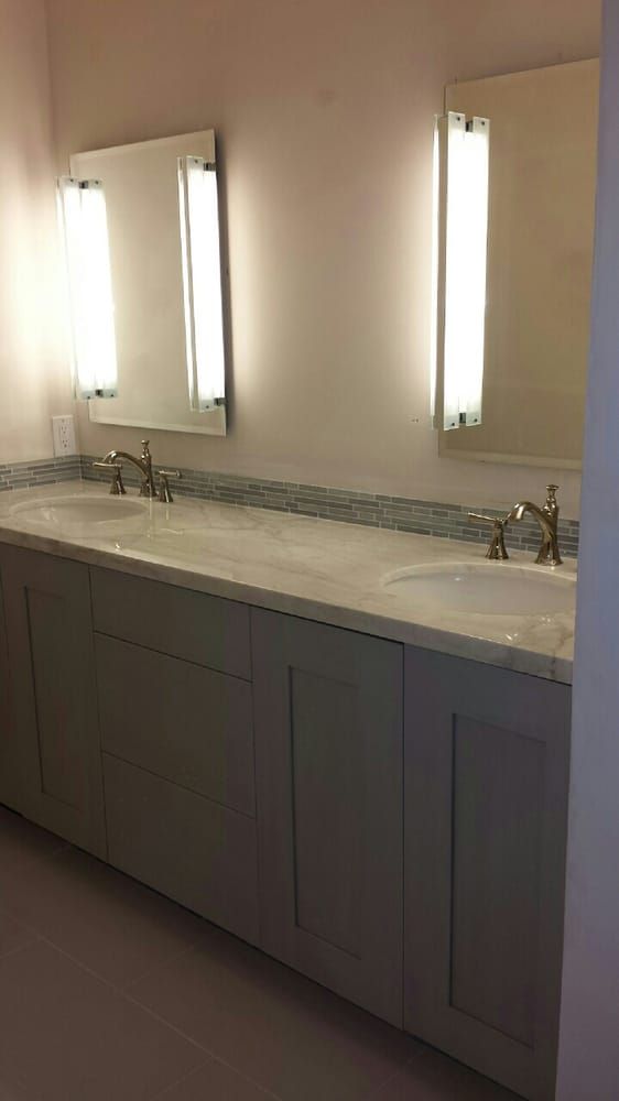 A bathroom with two sinks and three mirrors.