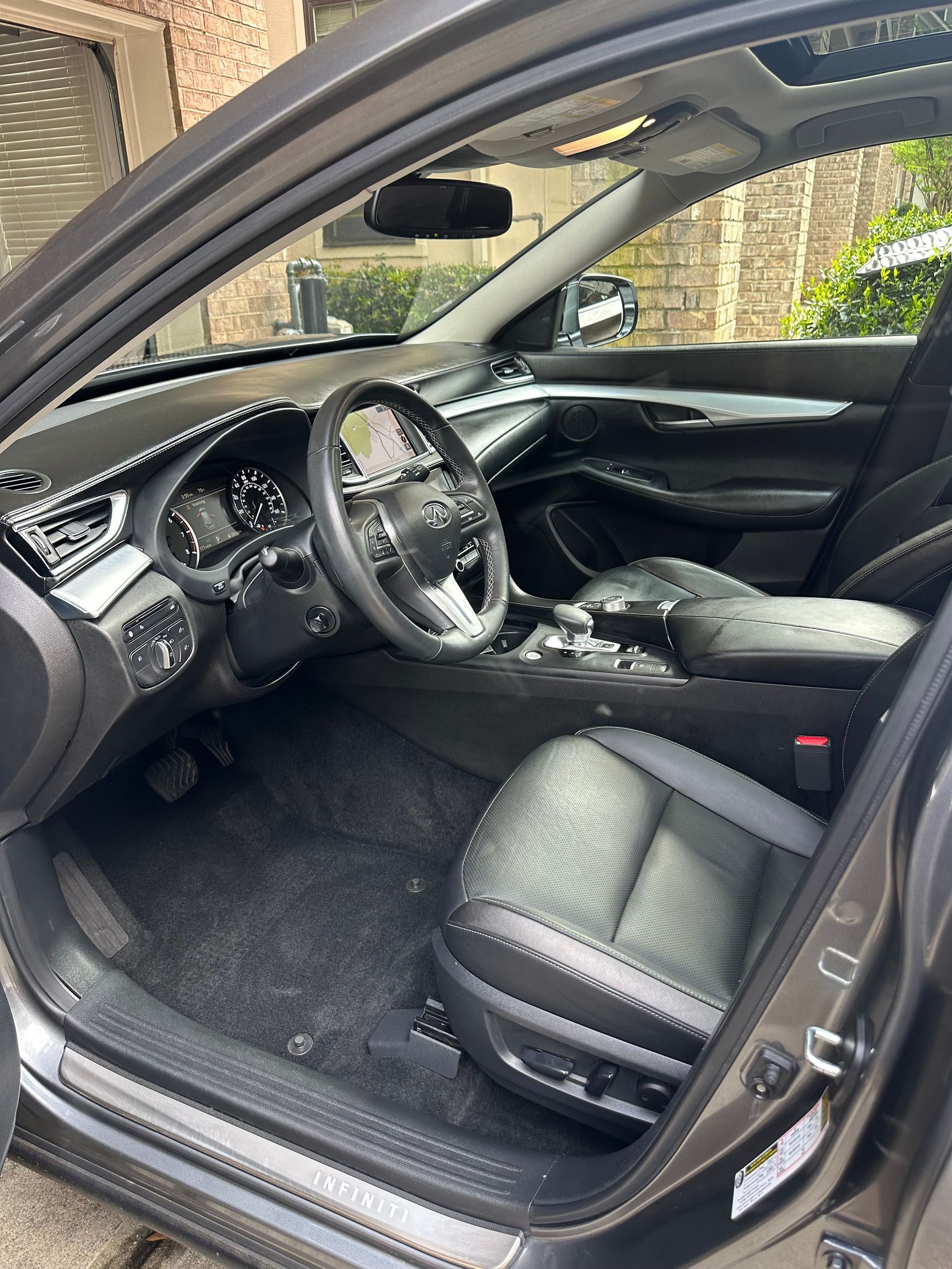 Gray car interior with black leather seats, steering wheel, and dashboard.