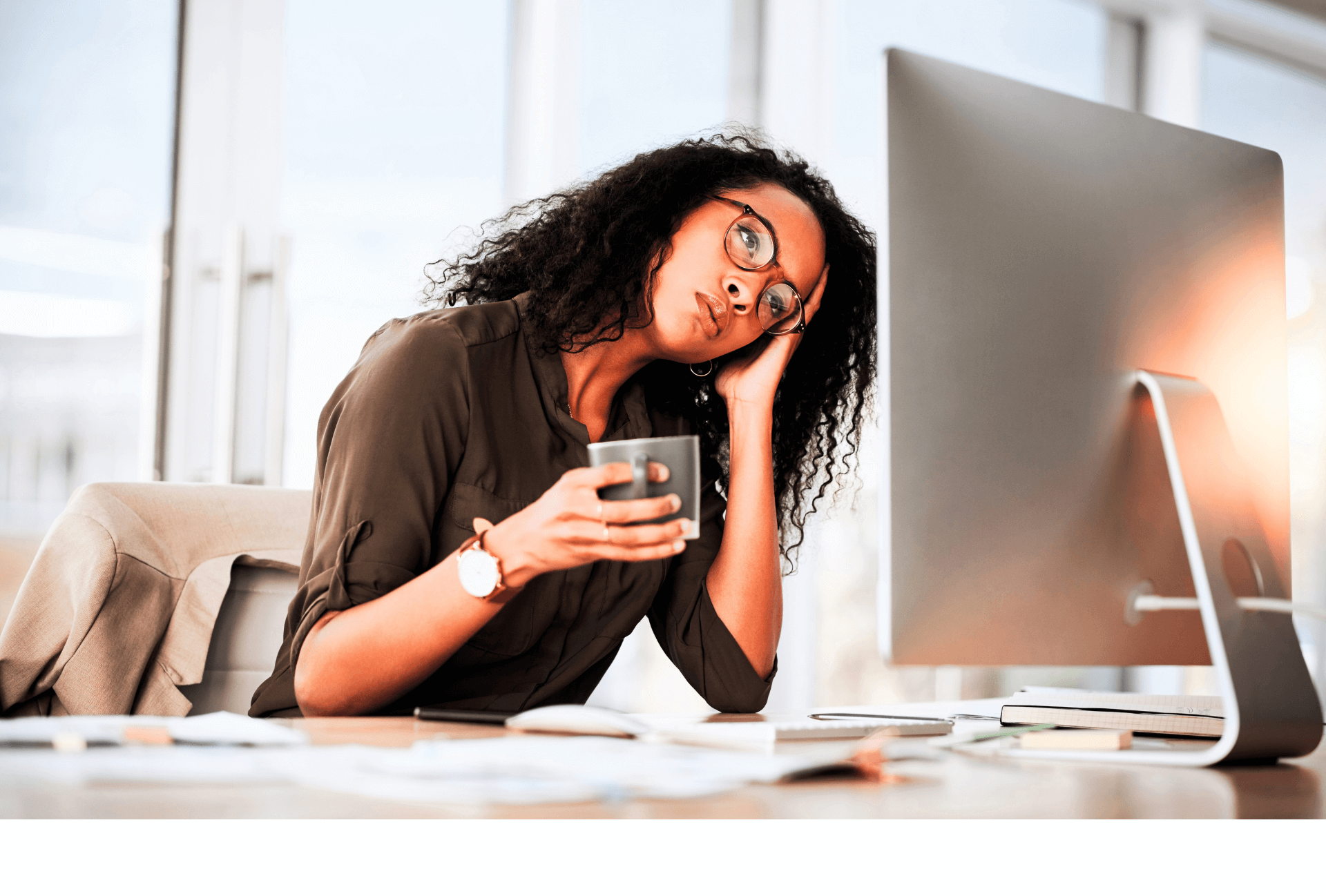 Femme devant un ordinateur, l'air fatiguée devant un site trop lent , tenant une tasse d une main