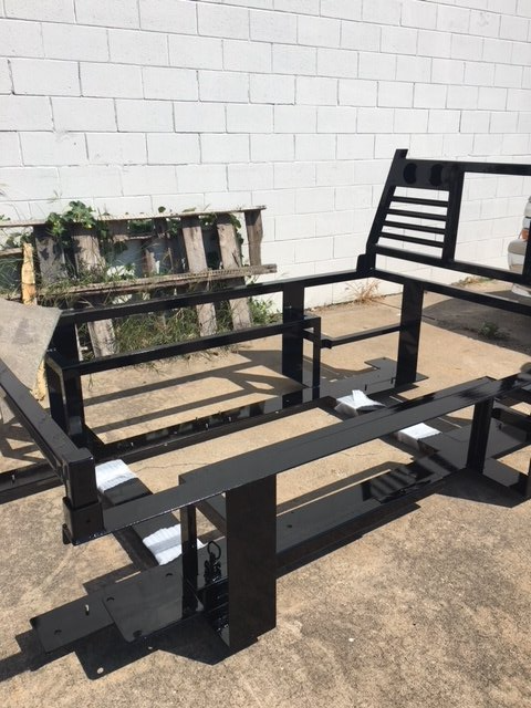 A black metal frame is sitting in front of a white brick wall