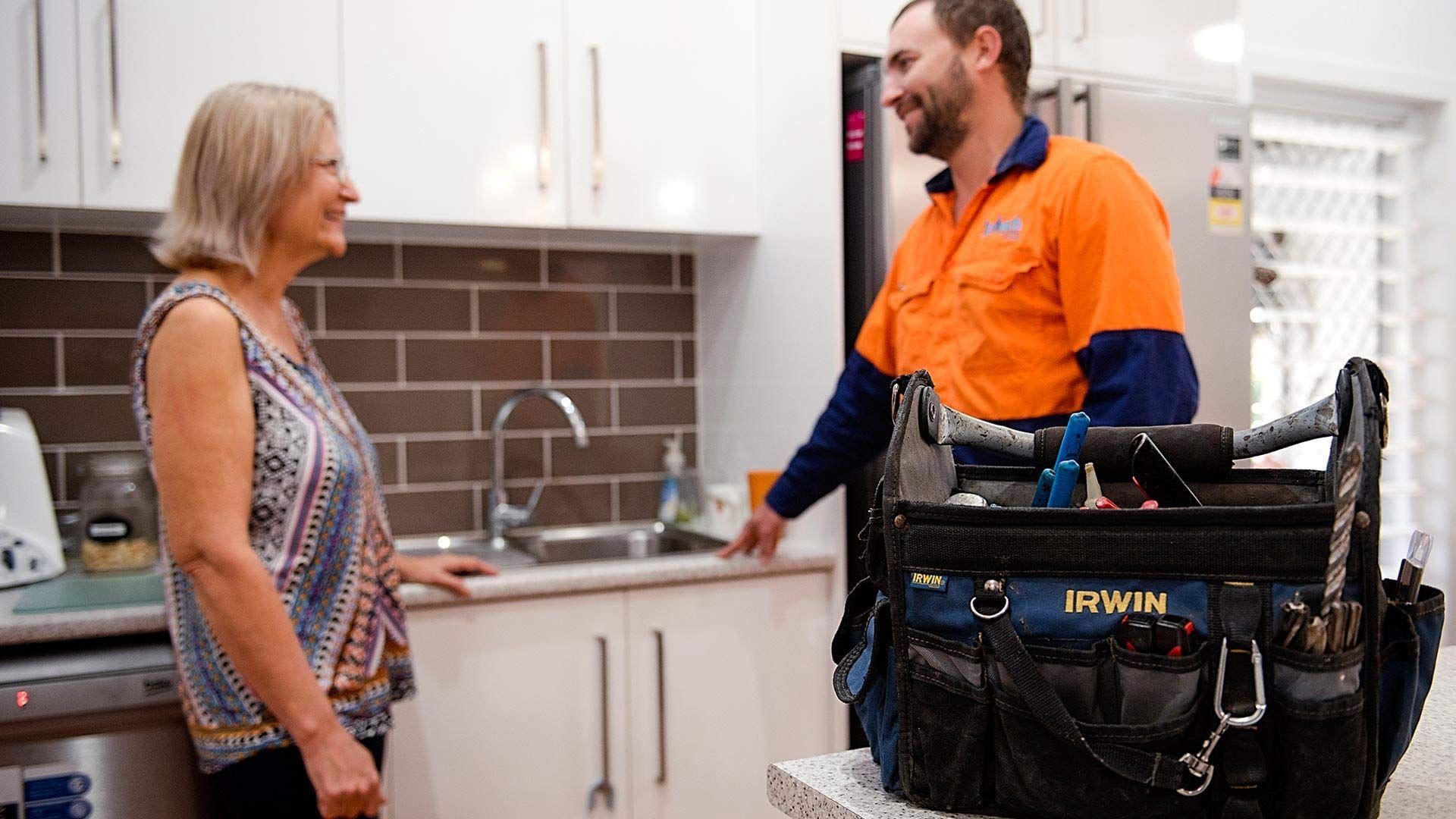 A plumber in Townsville talking to a homeowner