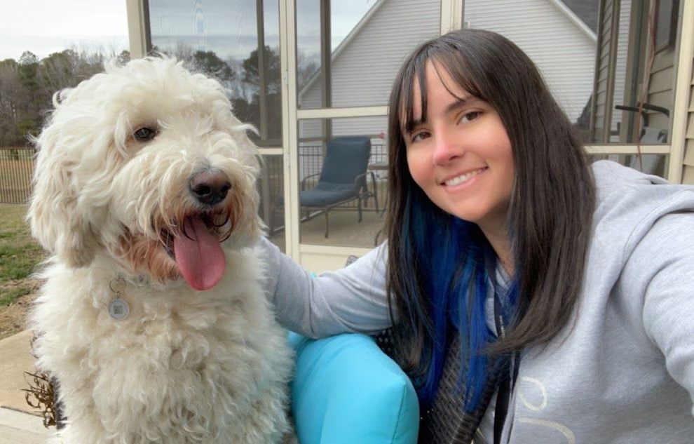 Dog and trainer taking a selfie while using the 'Place' command during a relaxing break between training sessions in Wendell, NC. Dog training in Wendell emphasizes the importance of structure, downtime, and positive reinforcement for balanced learning.