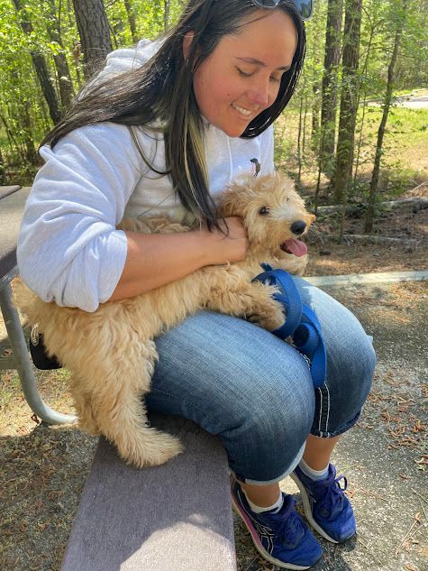 Trainer rewarding a dog with praise and love for a job well done while practicing commands on a trail hike in Wendell, NC. Dog training in Wendell focuses on positive reinforcement, helping dogs stay motivated and improve obedience in outdoor, distraction-filled environments.