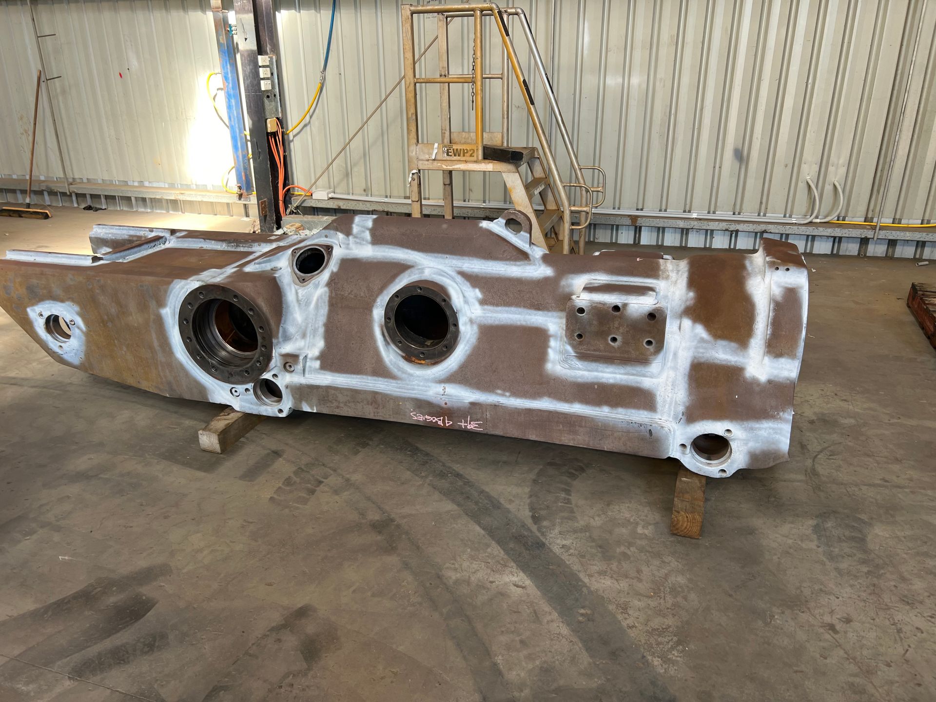 Yellow construction equipment on a wooden pallet, sitting on a shelf.