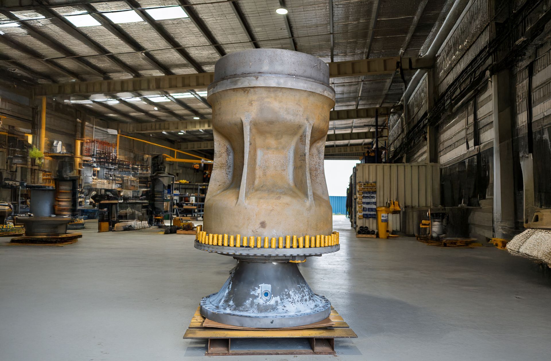 White arched storage structure with open doorway, container sides, and a forklift.