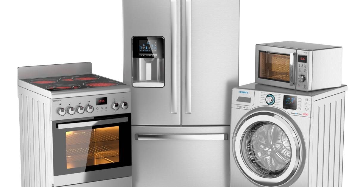 A group of stainless steel appliances. There is an oven and range, a refrigerator, a washing machine