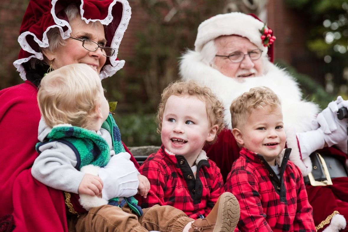 A group of children are sitting on a sleigh with santa claus.