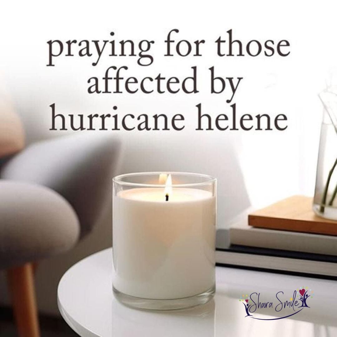 A candle on a table with the words praying for those affected by hurricane helene