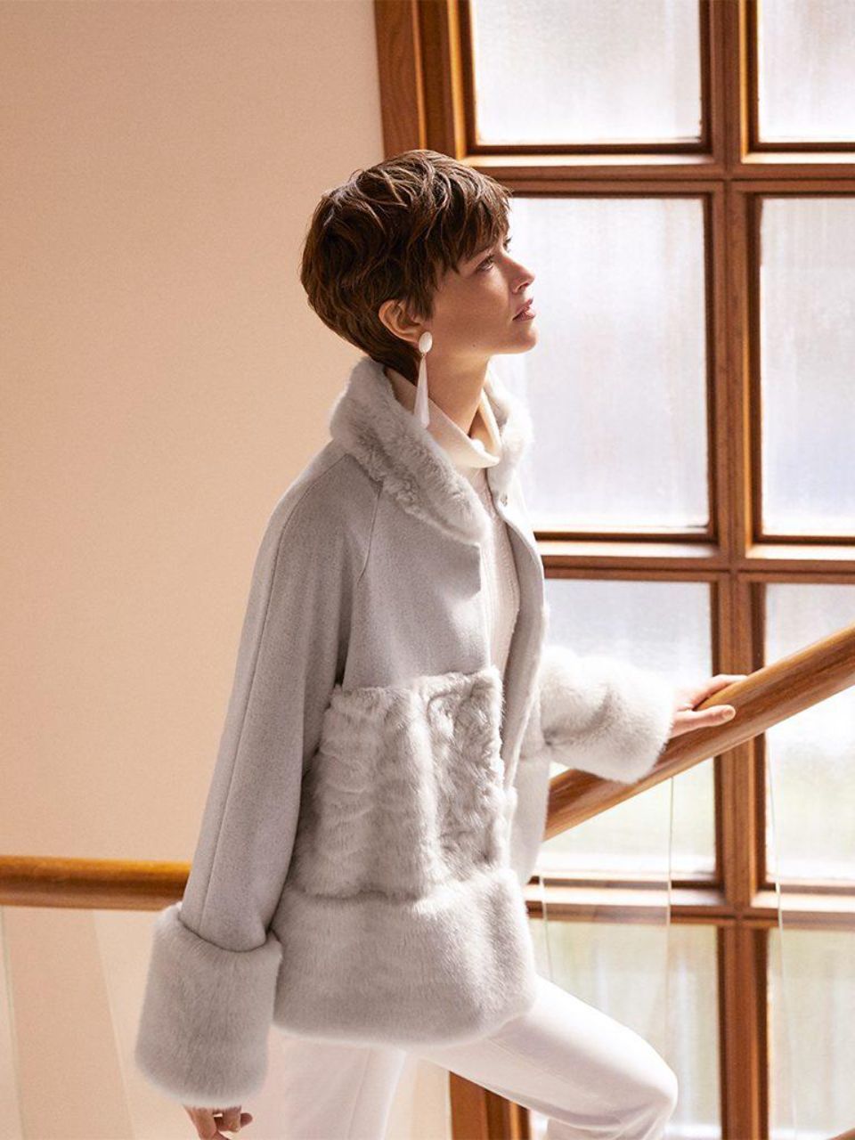 Donna che indossa un cardigan grigio con dettagli in pelliccia