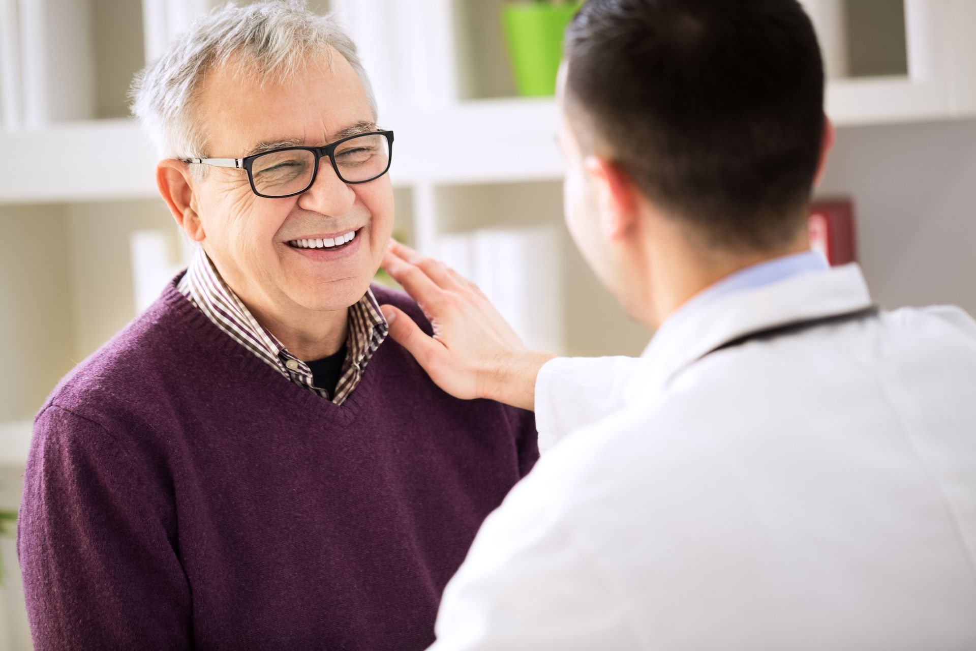 An elderly man is smiling while talking to a doctor at Twinlake.