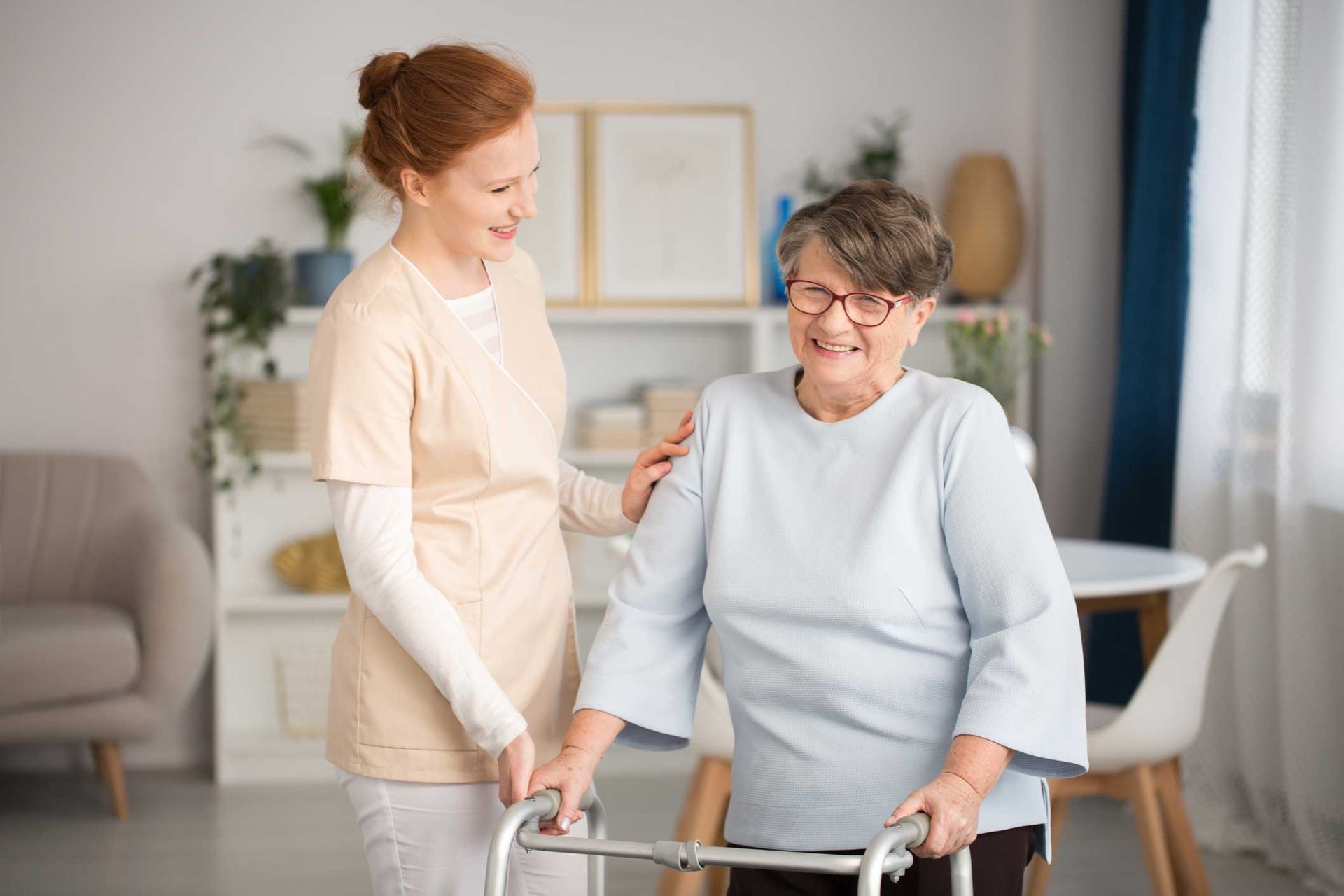 A nurse is helping an elderly woman with a walker.