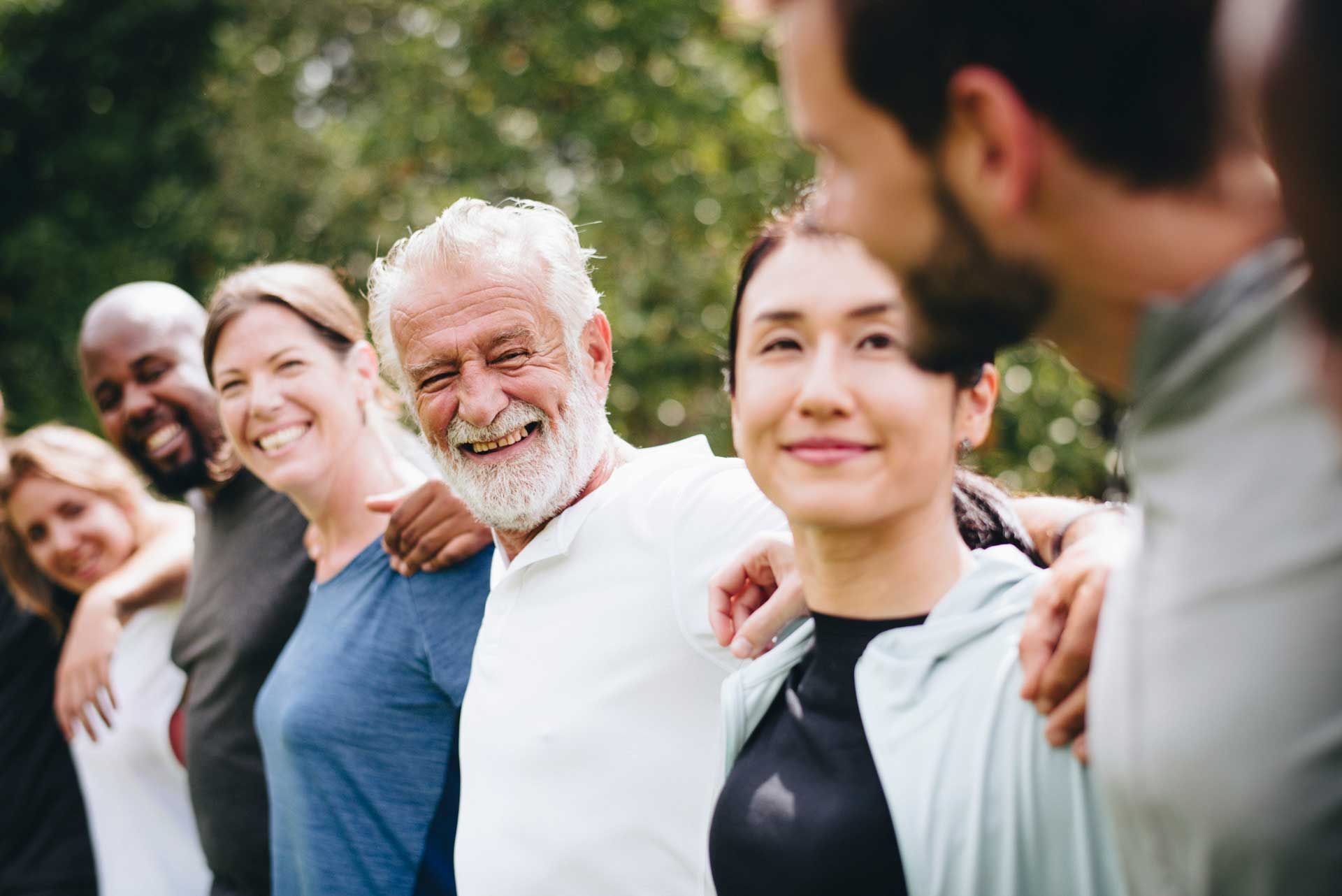 A group of people are standing next to each other in a park.