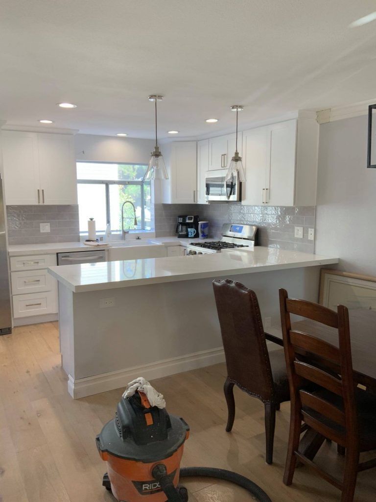 A vacuum cleaner is sitting in the middle of a kitchen.