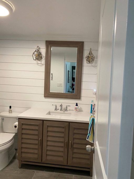 A bathroom with a sink , toilet and mirror.