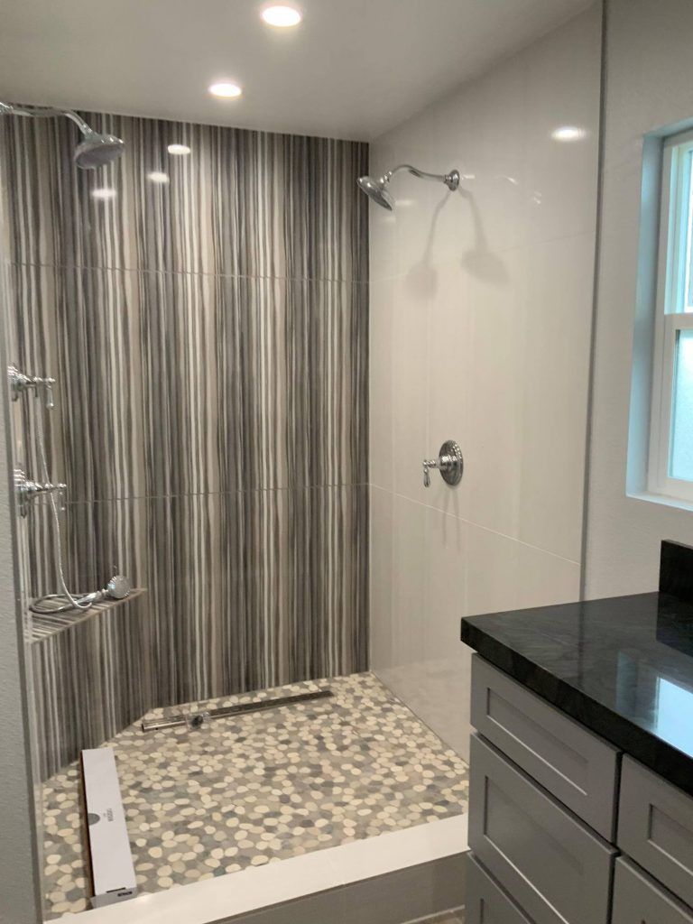 A bathroom with a walk in shower and a sink.