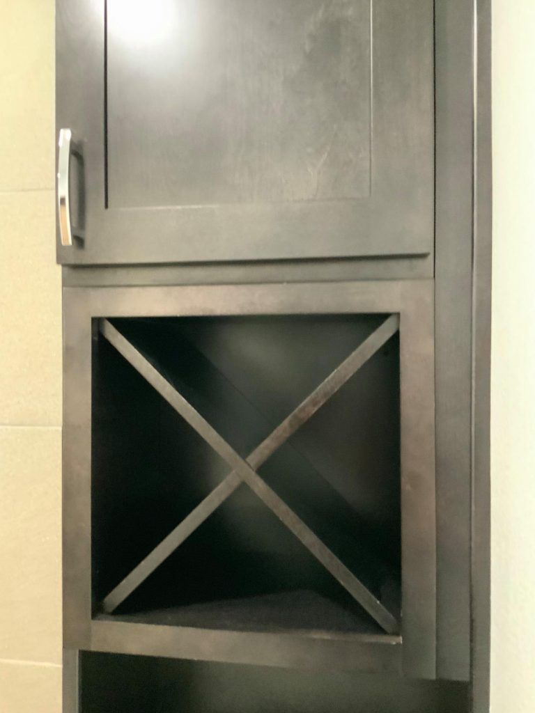 A black cabinet with a wine rack underneath it.
