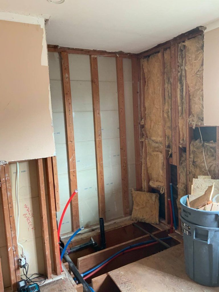 A bathroom under construction with a bathtub and a trash can.