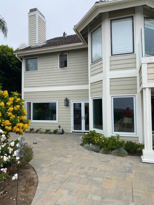 A large house with a lot of windows and flowers in front of it