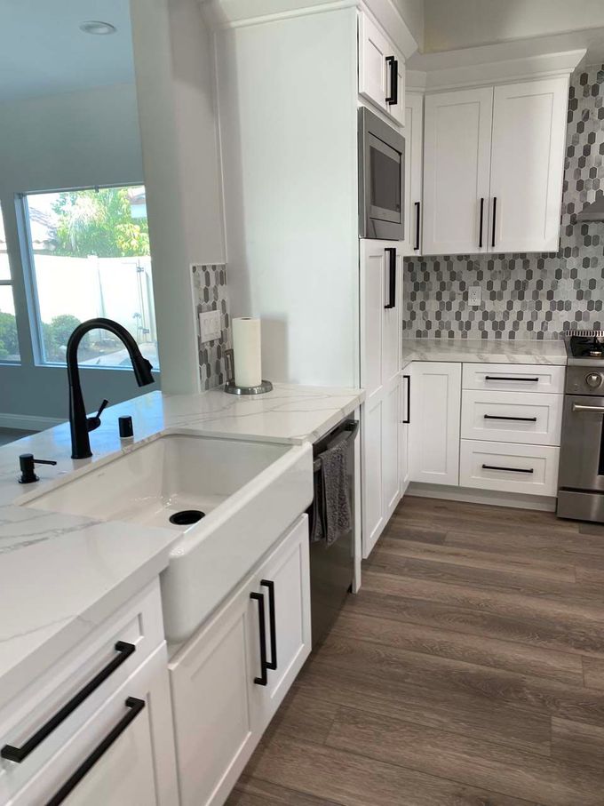 A kitchen with white cabinets and stainless steel appliances