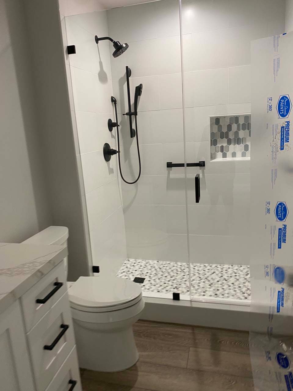 A bathroom with a toilet , shower , and vanity.