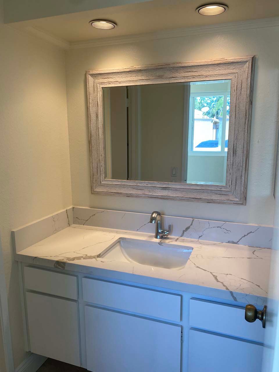 A bathroom with a sink and a large mirror