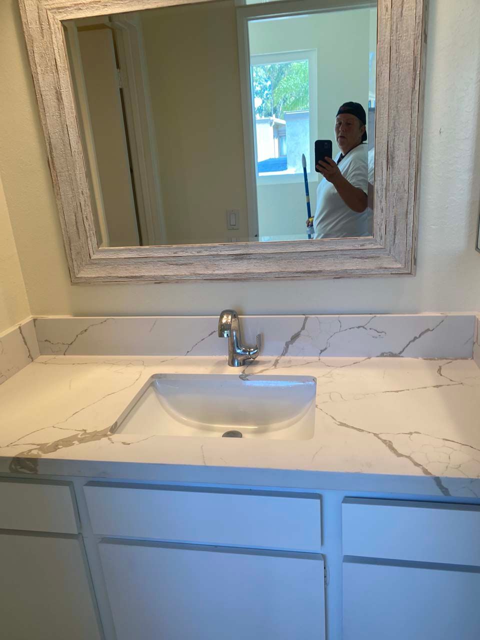 A man is taking a picture of himself in a bathroom mirror.