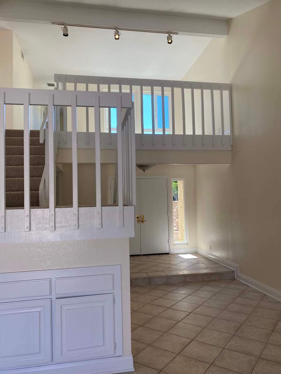 An empty room with a balcony and stairs leading up to it.