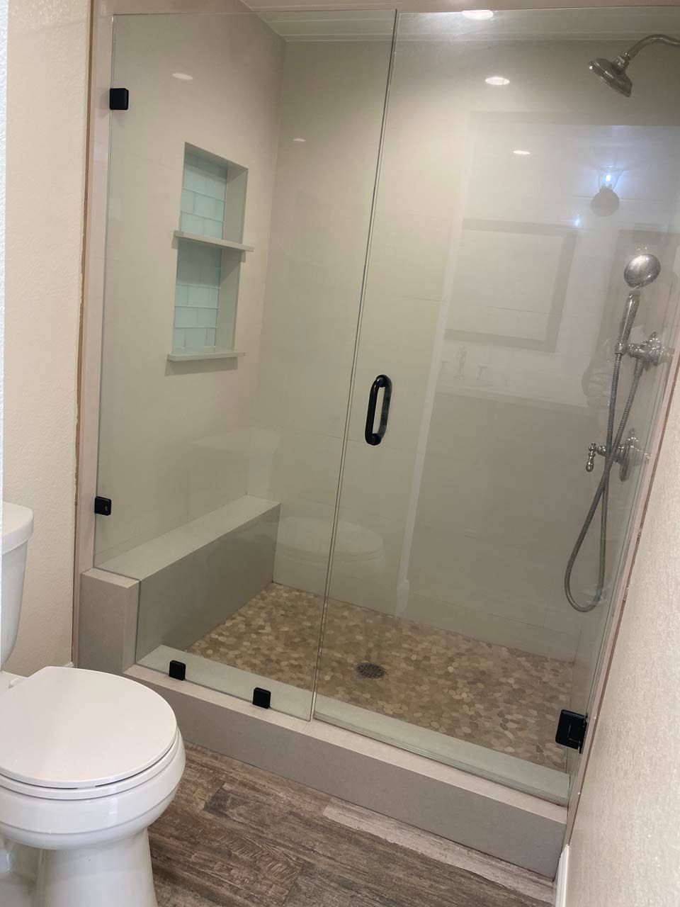 A bathroom with a toilet and a shower with a glass door.