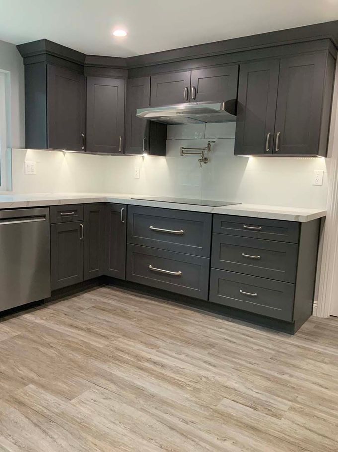 A kitchen with gray cabinets and stainless steel appliances.